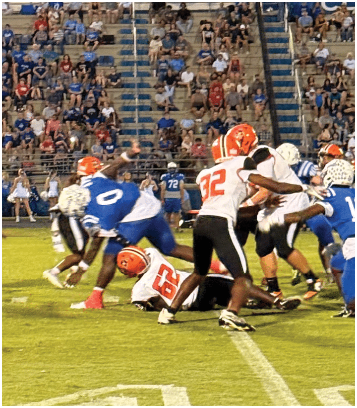 A group of football players wearing black and white uniforms. Description generated by AI