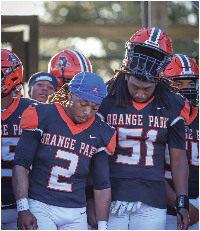 A group of football players wearing black and white uniforms. Description generated by AI