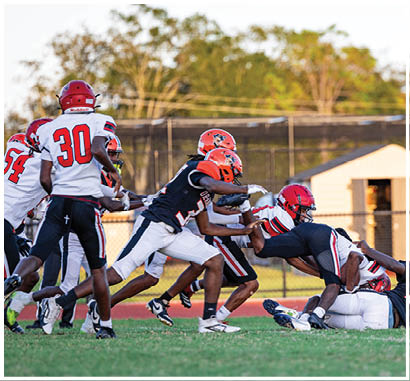 A group of football players huddled together on the field. Description generated by AI