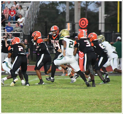 A group of football players huddled together on the field. Description generated by AI