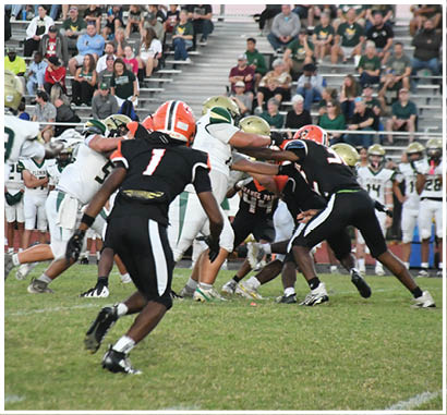 A group of football players huddled together on the field. Description generated by AI