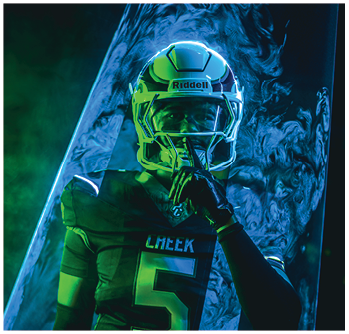 A person wearing a football helmet and jersey with the number five is holding a finger to their lips in a shushing gesture against a dark, smoky background. Description generated by AI
