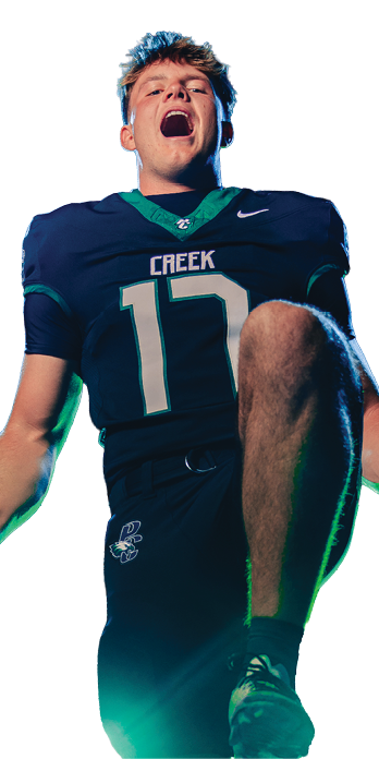 A person wearing a dark sports uniform with the number 17 is celebrating energetically with one knee raised and fists clenched. Description generated by AI