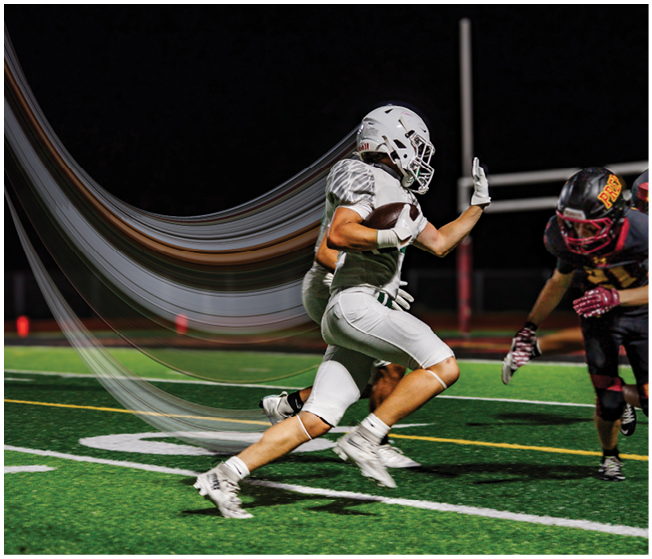 Two people in white football uniforms are running on a field at night while two people in black and red football uniforms approach them. Description generated by AI