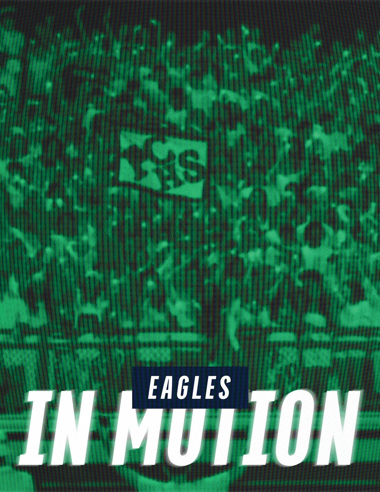 A crowd of people is gathered in a stadium with a sign that reads “Eagles" and large text below saying "In Motion." Description generated by AI