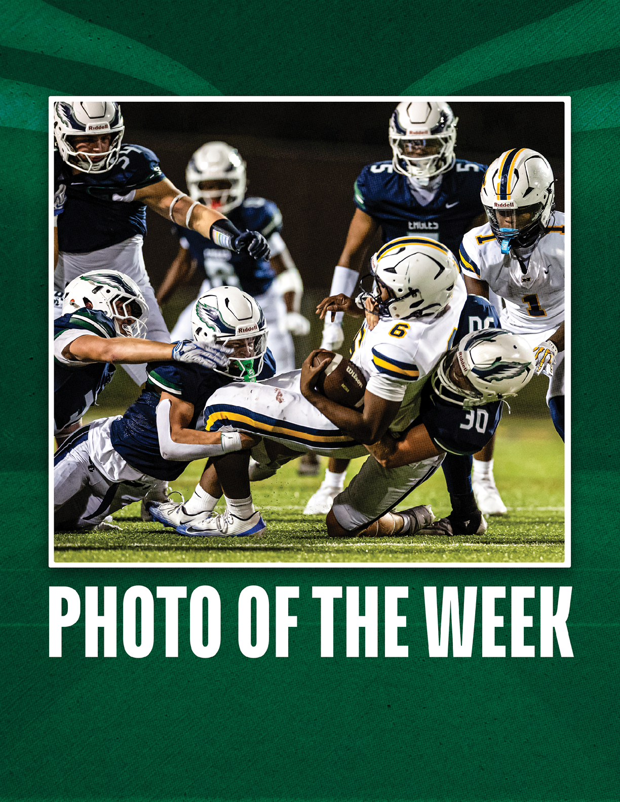 A group of people in football uniforms are engaged in a tackle on a grassy field during a game, with one person holding the ball while others attempt to stop them. Description generated by AI