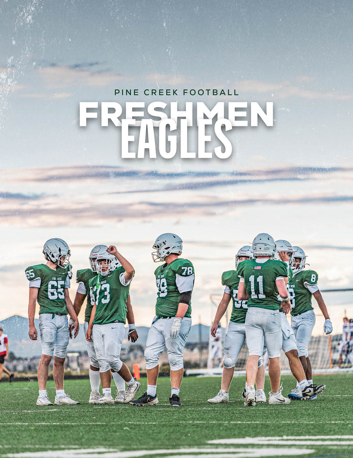A group of people wearing green and white football uniforms stand together on a grassy field under a cloudy sky with text above them reading Pine Creek Football Freshmen Eagles. Description generated by AI