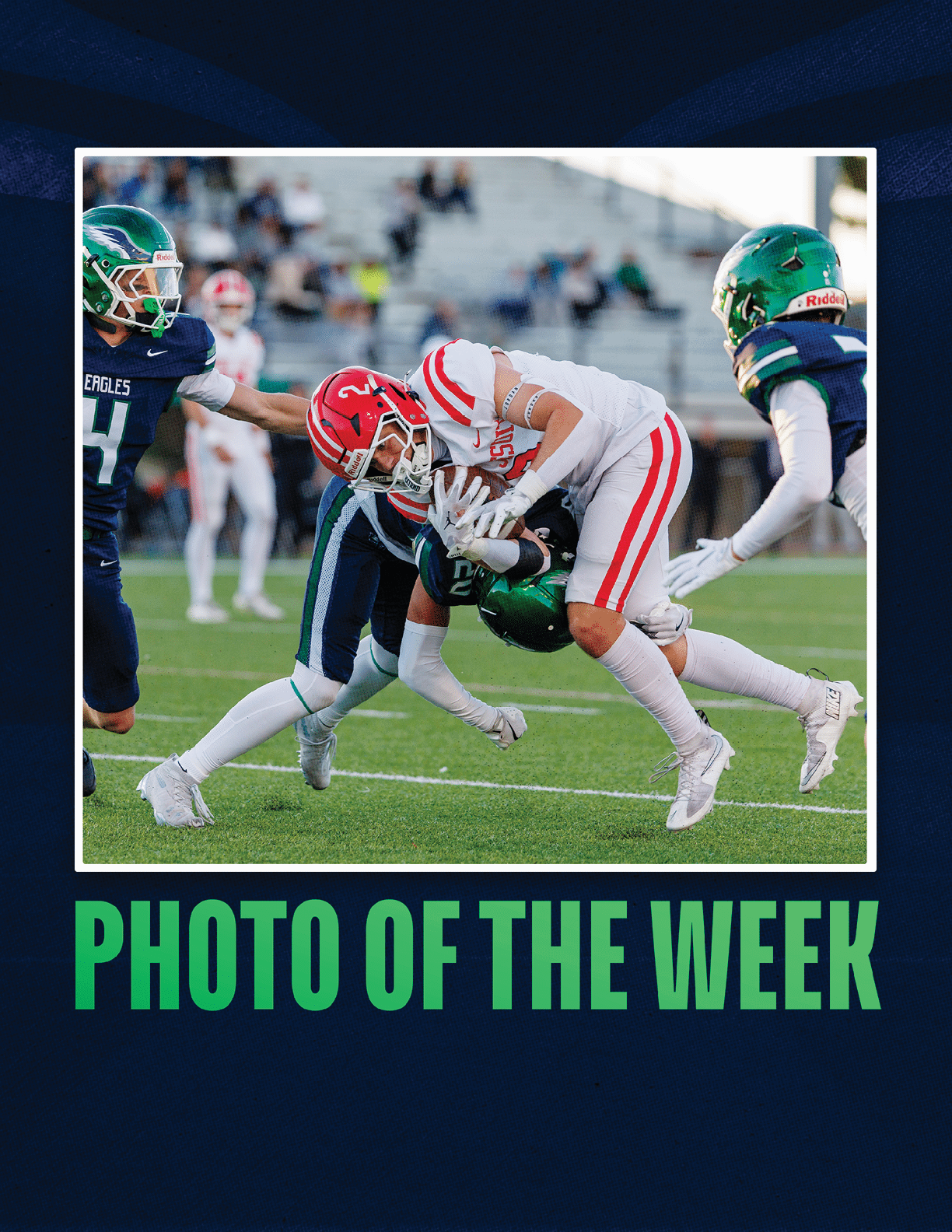 A group of people in football uniforms are engaged in a tackle on a grassy field during a game. Description generated by AI