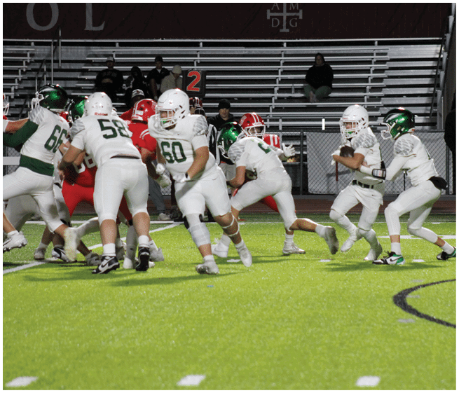 A group of people in football uniforms are actively playing on a field with one person holding the ball and others running or blocking near the sideline marker. Description generated by AI