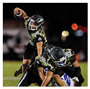 A football player wearing a blue and red jersey. Description generated by AI