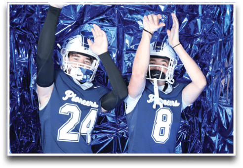 Three football players are standing on the field, one of them is smiling and wearing a black jersey with the number 55. AI generated content