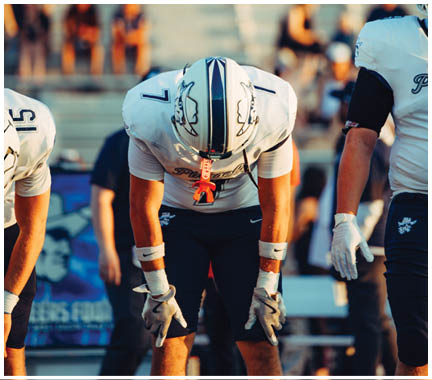 A football player wearing a blue and white uniform. Description generated by AI