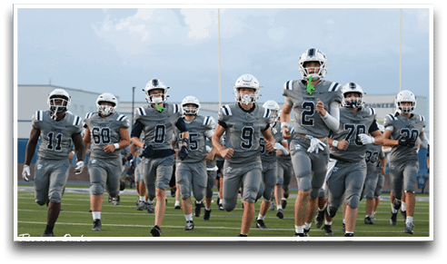 Three football players are standing on the field, one of them is smiling and wearing a black jersey with the number 55. AI generated content