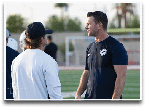 Three football players are standing on the field, one of them is smiling and wearing a black jersey with the number 55. AI generated content