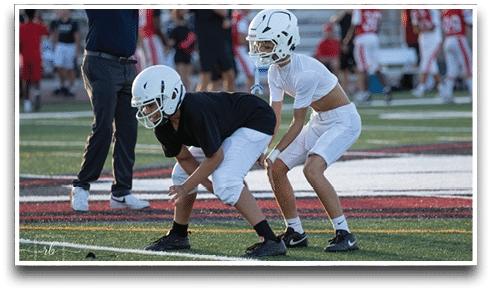Three football players are standing on the field, one of them is smiling and wearing a black jersey with the number 55. AI generated content