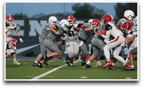 Three football players are standing on the field, one of them is smiling and wearing a black jersey with the number 55. AI generated content
