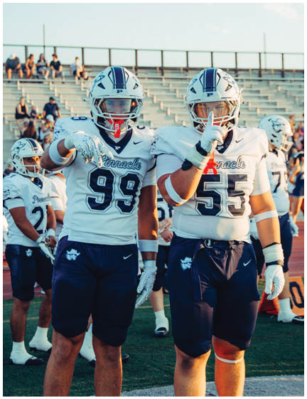A football player wearing a blue and white uniform. Description generated by AI