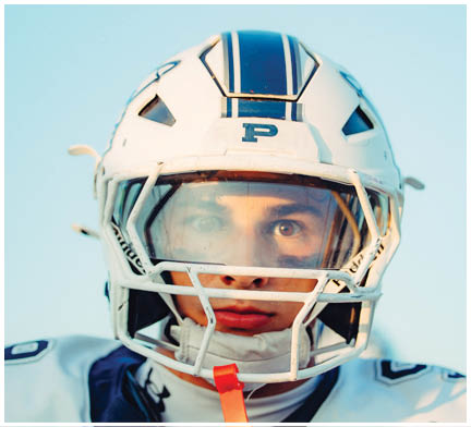 A group of football players huddled together on the field. Description generated by AI