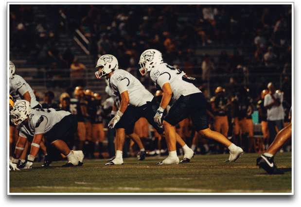 Three football players are standing on the field, one of them is smiling and wearing a black jersey with the number 55. AI generated content