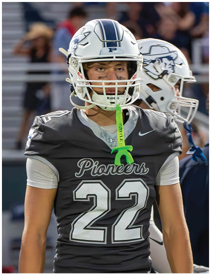 A football player wearing a blue and white uniform. Description generated by AI