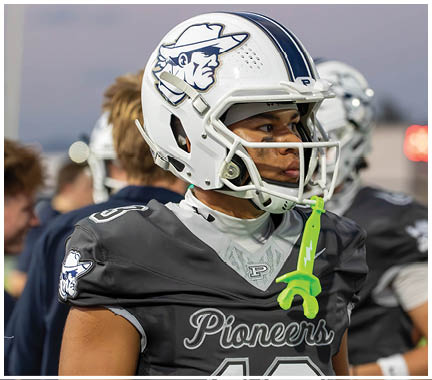 A football player wearing a blue and white uniform. Description generated by AI