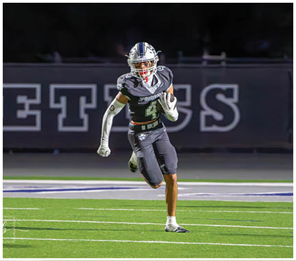 A football player wearing a blue and white uniform. Description generated by AI