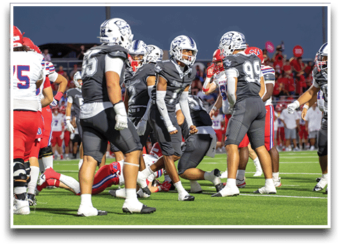 Three football players are standing on the field, one of them is smiling and wearing a black jersey with the number 55. AI generated content