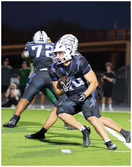 A football player wearing a blue and white uniform. Description generated by AI