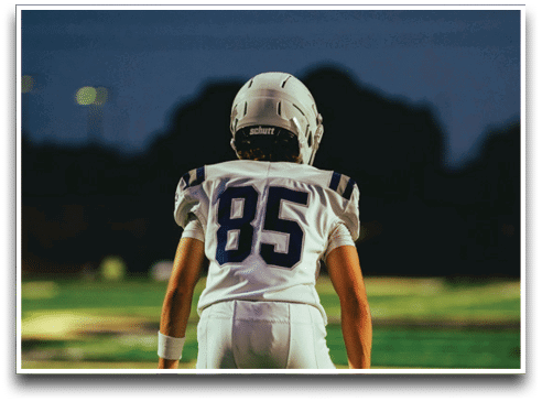 Three football players are standing on the field, one of them is smiling and wearing a black jersey with the number 55. AI generated content