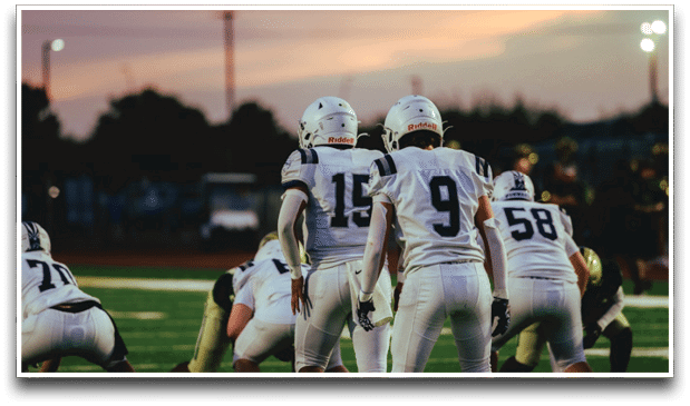 Three football players are standing on the field, one of them is smiling and wearing a black jersey with the number 55. AI generated content