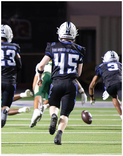 A football player wearing a blue and white uniform. Description generated by AI
