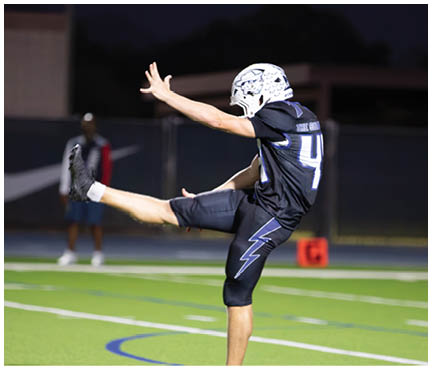A football player wearing a blue and white uniform. Description generated by AI