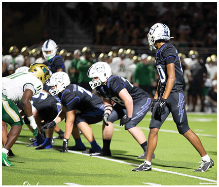 A football player wearing a blue and white uniform. Description generated by AI