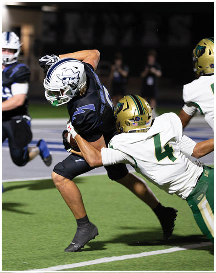 A football player wearing a blue and white uniform. Description generated by AI