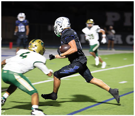 A football player wearing a blue and white uniform. Description generated by AI