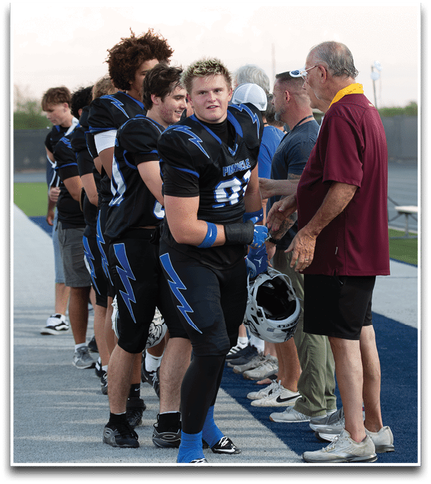 Three football players are standing on the field, one of them is smiling and wearing a black jersey with the number 55. AI generated content
