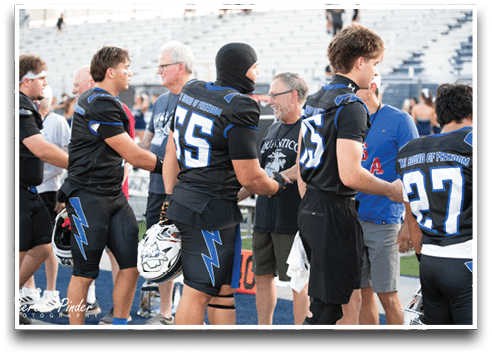 Three football players are standing on the field, one of them is smiling and wearing a black jersey with the number 55. AI generated content