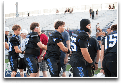 Three football players are standing on the field, one of them is smiling and wearing a black jersey with the number 55. AI generated content