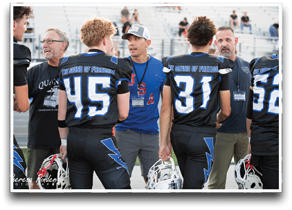 Three football players are standing on the field, one of them is smiling and wearing a black jersey with the number 55. AI generated content
