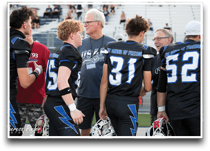 Three football players are standing on the field, one of them is smiling and wearing a black jersey with the number 55. AI generated content