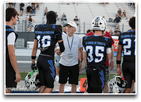 Three football players are standing on the field, one of them is smiling and wearing a black jersey with the number 55. AI generated content