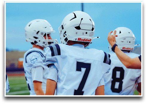 Three football players are standing on the field, one of them is smiling and wearing a black jersey with the number 55. AI generated content