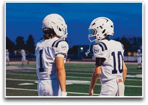 Three football players are standing on the field, one of them is smiling and wearing a black jersey with the number 55. AI generated content