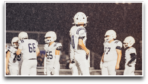 Three football players are standing on the field, one of them is smiling and wearing a black jersey with the number 55. AI generated content