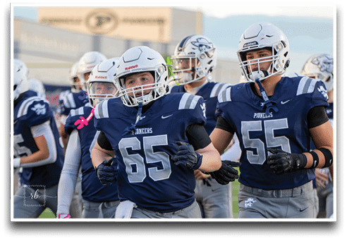 Three football players are standing on the field, one of them is smiling and wearing a black jersey with the number 55. AI generated content