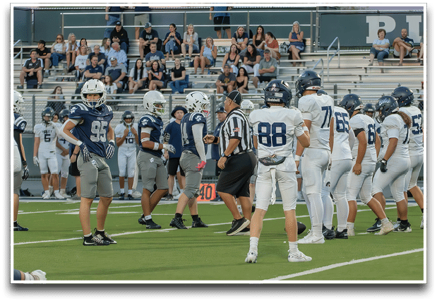 Three football players are standing on the field, one of them is smiling and wearing a black jersey with the number 55. AI generated content