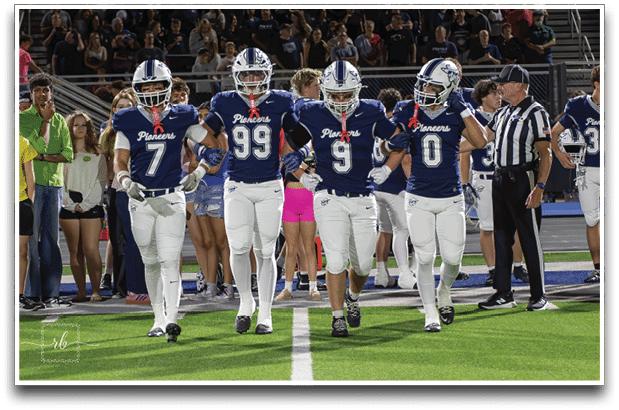 Three football players are standing on the field, one of them is smiling and wearing a black jersey with the number 55. AI generated content