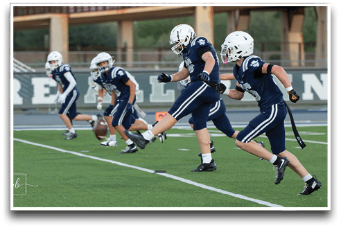 Three football players are standing on the field, one of them is smiling and wearing a black jersey with the number 55. AI generated content