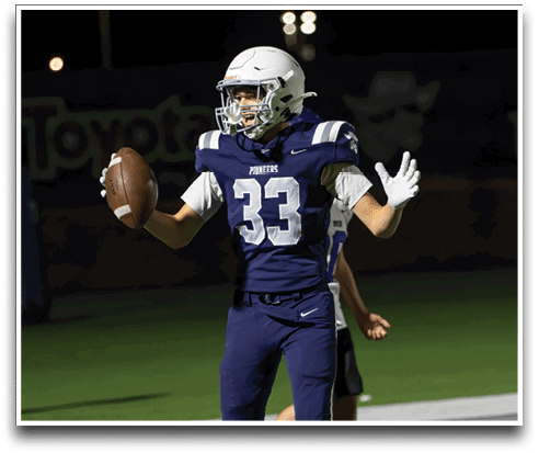 Three football players are standing on the field, one of them is smiling and wearing a black jersey with the number 55. AI generated content