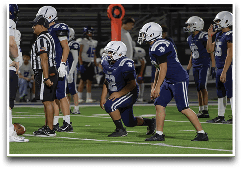 Three football players are standing on the field, one of them is smiling and wearing a black jersey with the number 55. AI generated content